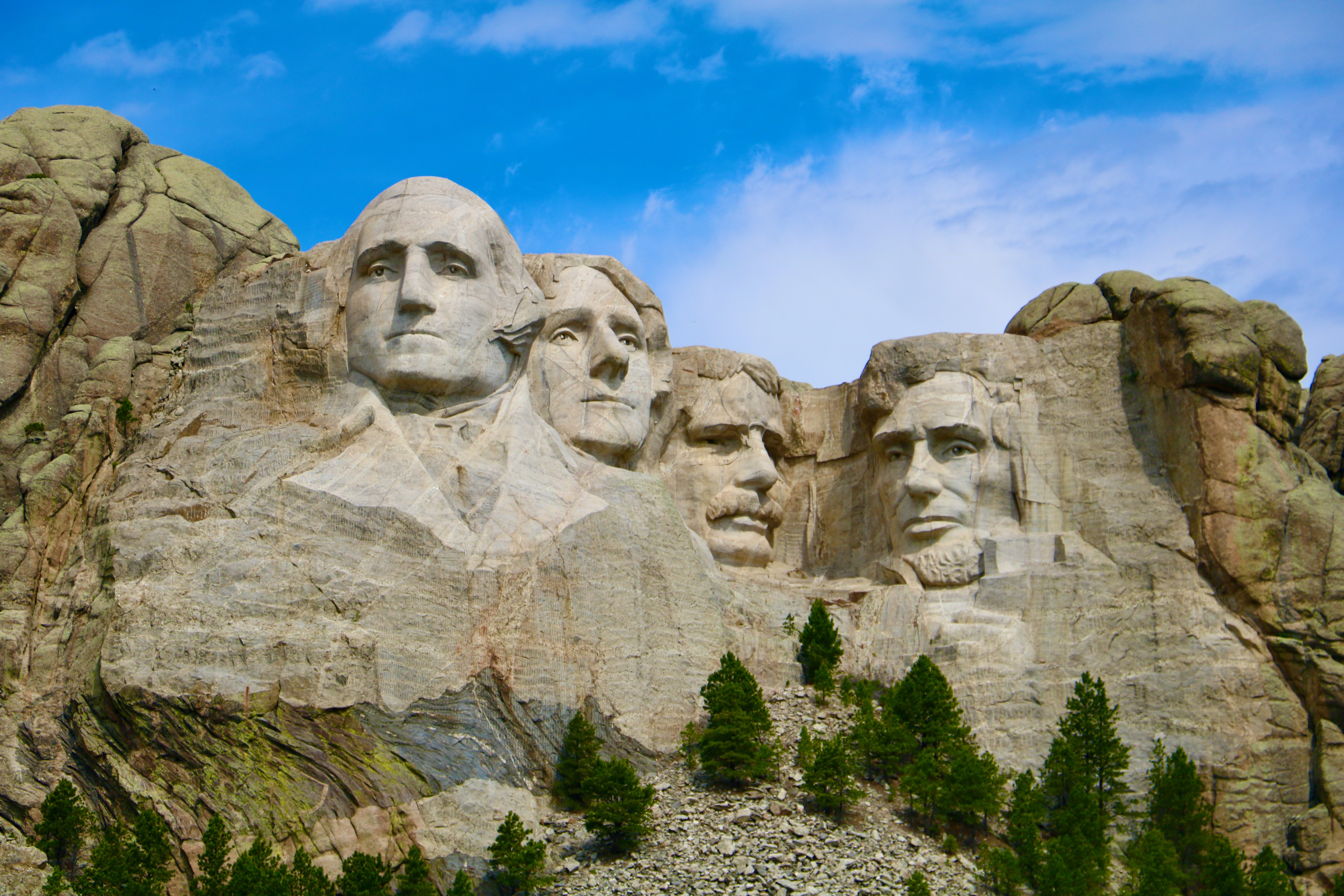 A group of four faces carved into the side of a mountain.