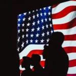 A man and woman are silhouetted against the american flag.